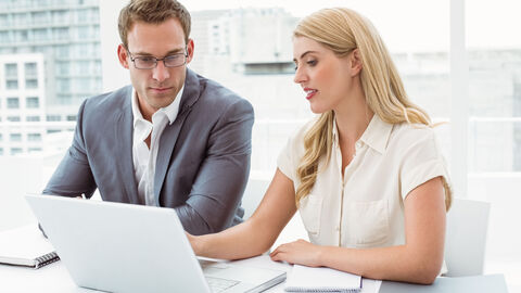 Mann und Frau schauen gemeinsam am Rechner 