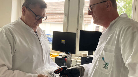 Zwei Laboranten scannen einen QR-Code auf einer Bodenprobe