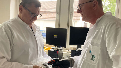 Zwei Laboranten scannen einen QR-Code auf einer Bodenprobe