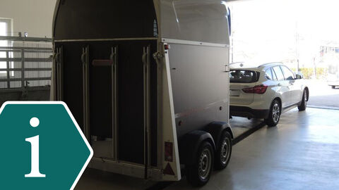Pferdeanhänger, der rückwärts in die Sektionshalle von einem Auto geschoben wird