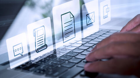 Hände, die auf einer Tastatur etwas eintippen.